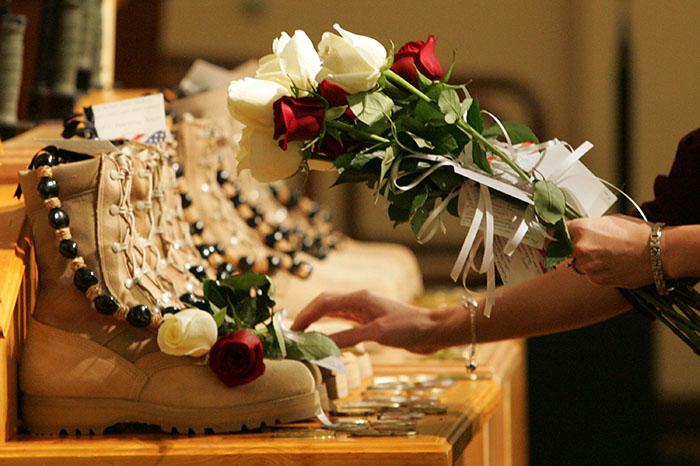 Seven pairs of boots are memorialized at Fort Lewis, Washington, Tuesday, November 10, 2009, with flowers, beads and coins following a memorial service for seven U.S. Army soldiers who were killed by an IED in Afghanistan. (Janet Jensen/Tacoma News Tribune)