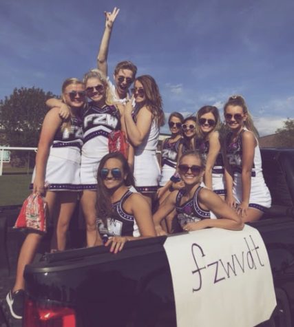 The varsity dance team spreads the homecoming excitement by riding in the back of a truck, throwing treats to the people lining the streets. “My favorite part was being able to celebrate the spirit of the school with my best friends and the team that I have grown so close to,” sophomore Halley Taylor said. 