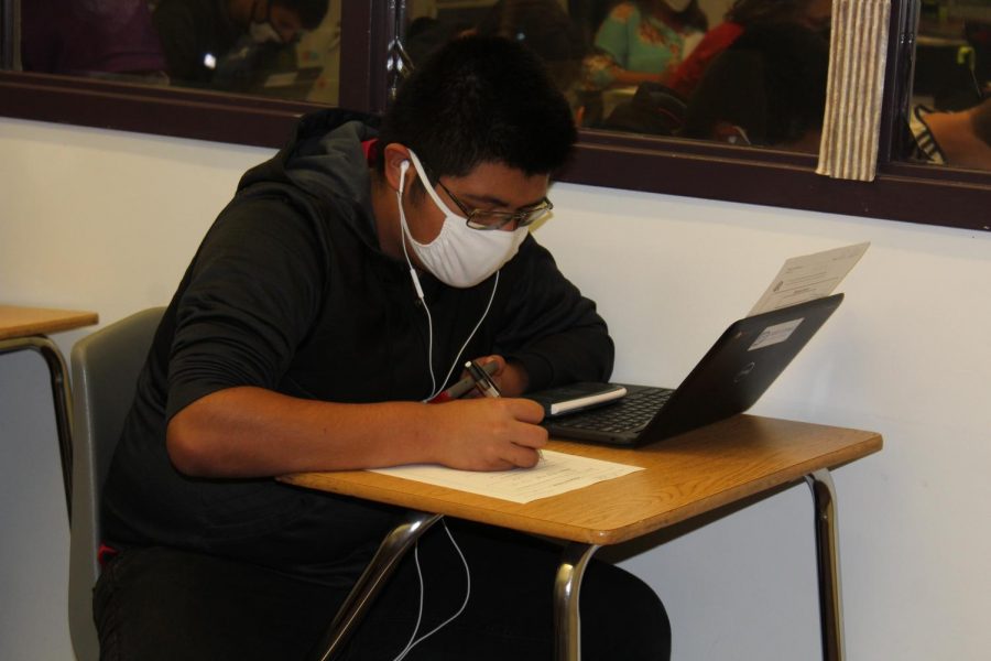 Student quietly studies while listening to music to help with the background noise.