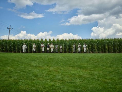 Field of Dreams actors walk out of the cornfield.