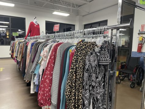 Goodwill is a store where one can go to shop resale. Clothes are shown on the womens section racks.