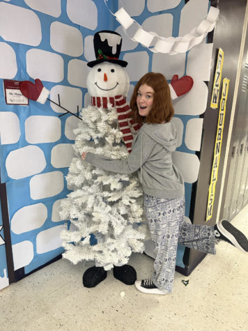 Senior Reese Crawford dressed cozy posing with a snowman