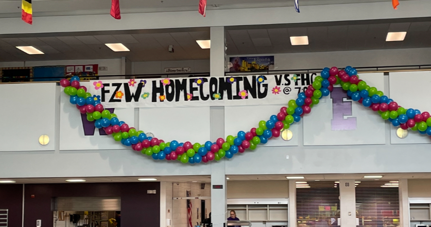 Homecoming game banner is hung up in the commons.